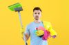 Man standing wearing plastic gloves and holding cleaning equipment and sweeping brush